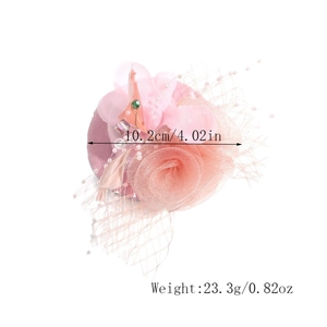 Detail of light pink floral mesh fascinator with beads and green gemstone core