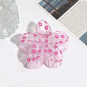 Dettaglio molletta per capelli a fiore in resina rosa con glitter e stampe floreali chic