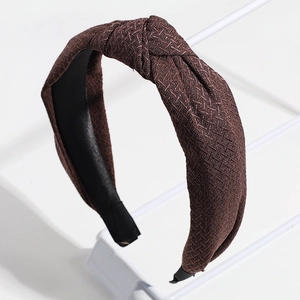 Gros plan sur le bandeau noué marron foncé montrant les détails de la texture tissée