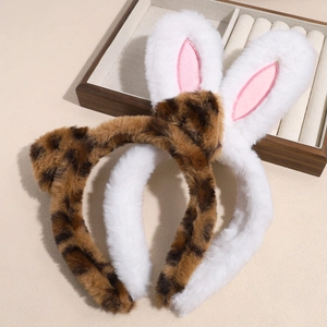 Plush leopard print and white rabbit ear headbands set on a wooden display tray