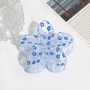 Dettaglio molletta per capelli a fiore azzurro con glitter in un ambiente lifestyle