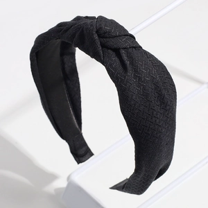 Détail du serre-tête noir noué montrant la texture du tissu en polyester tissé