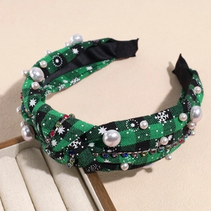 Detail of Christmas headband with green plaid fabric, white pearls and snowflake patterns