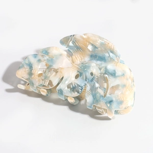 Detailed close-up of blue marble leaf cellulose acetate hair claw clip for women