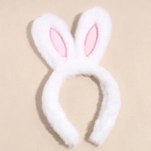 Close-up of white plush bunny ear headband with pink inner lining on beige background