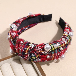 Close-up of Christmas knotted headband with red plaid pattern, pearls, and rhinestones