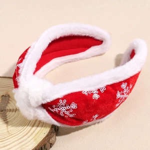 Close-up of red plush Christmas headband with white sequin snowflakes and fur trim