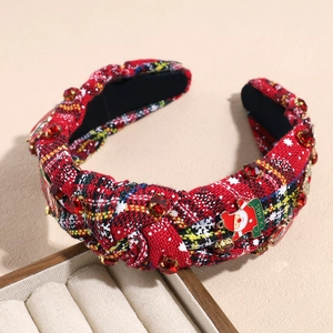 Detail of Christmas headband with red plaid fabric, Xmas charm and bells on wooden box