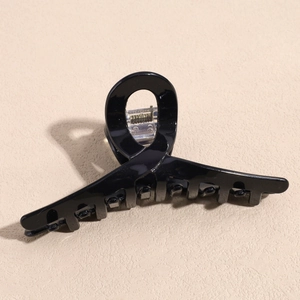 Detail der eleganten schwarzen glänzenden Haarklammer mit gedrehtem geometrischem Design