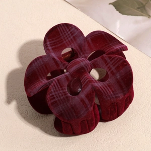 Detail view of burgundy flocked flower hair claw with elegant plaid pattern texture