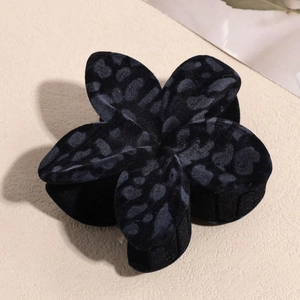 Detail shot of a black velvet plumeria hair claw clip with a leopard animal print pattern