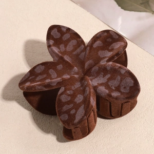 Macro detail of brown flocked frangipani hair claw clip with leopard pattern texture