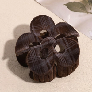Close-up of brown flocked plaid frangipani hair claw clip with golden metal spring