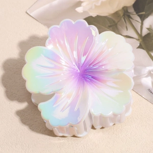 Macro detail of large floral hair claw clip featuring iridescent gradient resin finish