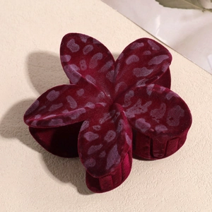 Macro shot of the wine red flocked velvet flower hair claw with dark leopard print detail