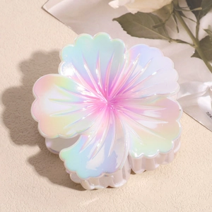 Macro view of iridescent resin flower hair claw clip with colorful gradient petals