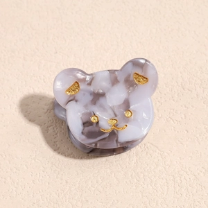Dettaglio molletta a forma di orso in acetato colorato con marmo glitterato oro