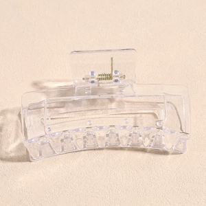 Macro detail of transparent square hair claw clip with golden metal spring and anti-slip teeth