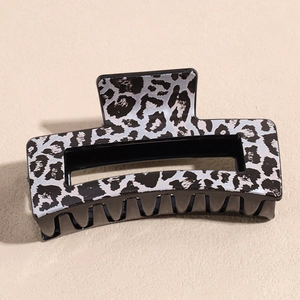 Close-up of a large leopard print hair claw clip in grey and black resin finish