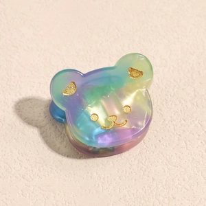 Macro di una clip per capelli a orsetto in acetato sfumato con glitter dorati