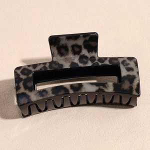 Detail of a large square leopard print hair claw clip showing a matte grey and black pattern