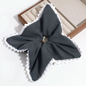 Detail of grey fabric scrunchie with white lace edges and star shape layered design