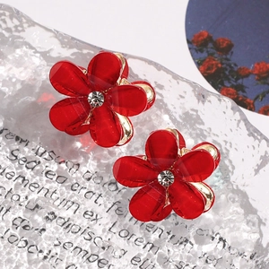 Detail of red camellia hair claw clips with rhinestones and gold metal base