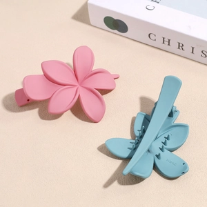 Fermagli per capelli a forma di fiore opaco in rosa e verde acqua su sfondo materico