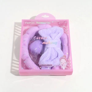 Purple plush spa headband and wristband set in a clear plastic gift display box
