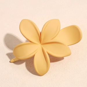 Dettaglio di una piccola molletta a forma di fiore di frangipane giallo in resina opaca