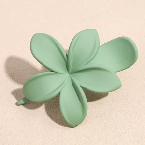 Dettaglio di un fermaglio per capelli a fiore verde menta con finitura opaca liscia