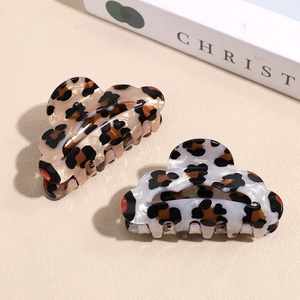 Stylish leopard print acetate claw clips set in warm amber and white tortoiseshell patterns
