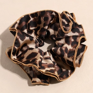 Detail view of the glossy satin leopard print oversized scrunchie texture and edge stitching