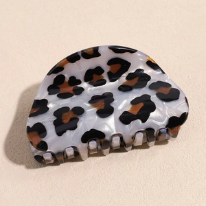 Detail of pearlescent white acetate hair claw clip with brown leopard print and fine teeth