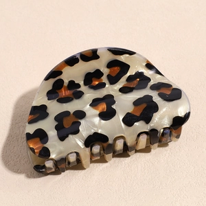 Macro shot of stylish leopard print hair claw clip showing polished acetate texture