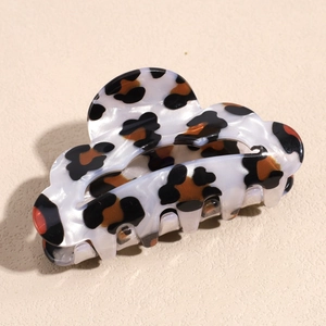 Macro detail of cloud-shaped acetate hair claw clip with leopard pattern and pearly finish