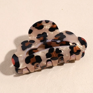 Close-up of leopard print acetate hair claw clip with unique wavy cloud-shaped edge design