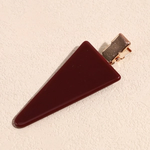 Close-up of a deep red triangle resin hair clip with a rose gold metal duckbill clamp