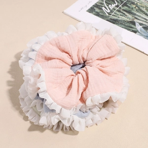 Pastel cotton linen scrunchies with white pleated edges displayed on beige background