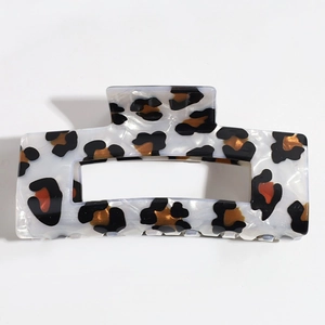 Detail of a white marble acetate hair claw clip with a stylish leopard print pattern