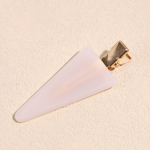 Detailed view of pale pink triangular acetate hair clip with golden metal alligator clamp