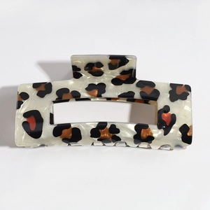 Detail of a rectangular leopard print acetate hair claw clip with a marble texture