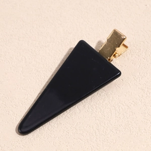 Detailed view of a sleek black geometric acetate hair clip with a gold metal duckbill base