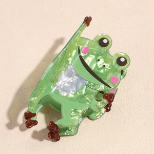 Detail der grünen Frosch Haarklammer aus Acryl mit Marmor-Textur und niedlichem Cartoon-Design