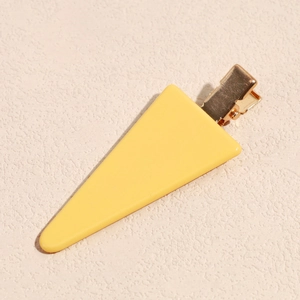 Detailed top view of a minimalist yellow acetate triangle hair clip with golden base