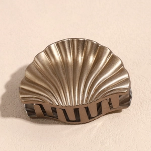 Macro detail of the bronze shell hair claw with metallic shell texture and strong teeth