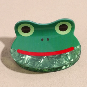 Detailansicht der grünen Cartoon Frosch Haarklammer mit Marmor-Textur-Effekt
