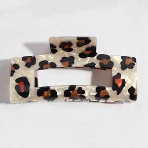 Detailed macro view of leopard print acetate hair claw clip with cream base and dark spots