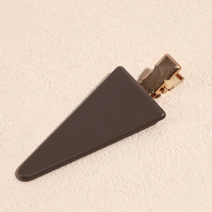 Detailed close-up of a dark brown acetate triangle hair clip with a golden metal duckbill