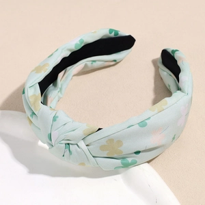 Détail du serre-tête noué en tissu vert menthe à fleurs avec doublure antidérapante
